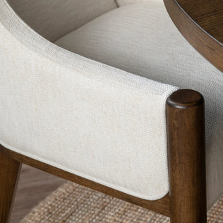 Close-up of a chair with wooden frame and white cushioned seat and backrest. Brunswick Dining Chair