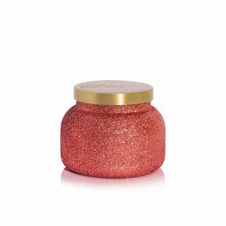 A Capri Blue Apple cider social pink glittery glam candle jar with a round shape and a gold lid. Capri Blue Apple Cider Social Signature Glam Jar