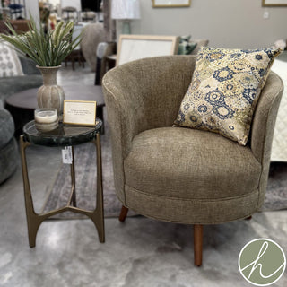 The Corentin side table features a stylish olive green glass top and is supported by a sturdy antique brass three-leg base.