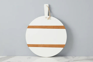 A white round charcuterie board with strips of wood in contrasting brown colors, featuring a white wax finish and a hanging loop. ETU White Round Charcuterie Board