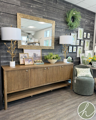 Wooden sideboard with four doors and a shelf on a white background medium stain gold knobs