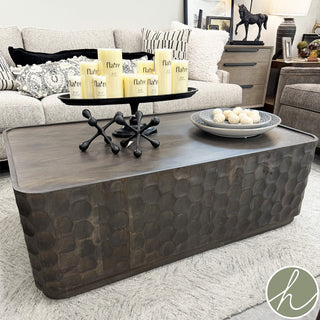 Living room with a textured coffee table, candles, and decorative items.