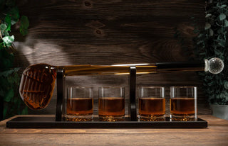 A whiskey decanter set featuring a golf club-shaped decanter and four whiskey glasses arranged on a mahogany wood base.