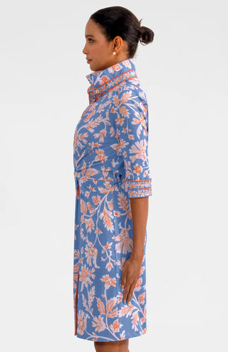 A model wearing a Gretchen Scott Twist & Shout Dress with ¾ sleeves, a center front racer stripe banding, and a floral pattern in periwinkle colors.