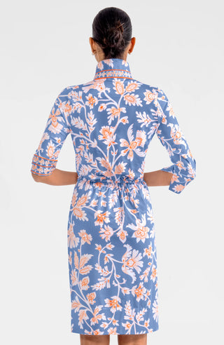 A model wearing a Gretchen Scott Twist & Shout Dress with ¾ sleeves, a center front racer stripe banding, and a floral pattern in periwinkle colors.