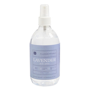 Clear spray bottle with lavender label on a white background
