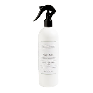 A white spray bottle labeled Hillhouse Naturals Yuzu Sage Linen Mist with a black trigger sprayer.
