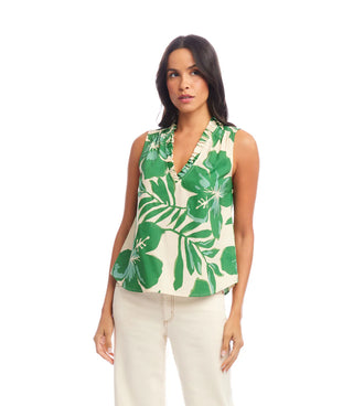 Woman wearing a sleeveless top with green floral pattern on a white background
