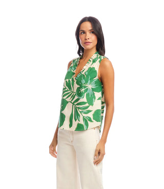 Woman wearing a sleeveless top with green leaf pattern on a white background