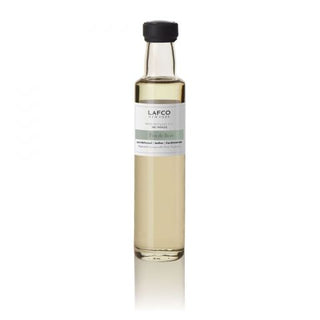 A bottle of LAFCO Feu De Bois Diffuser Refill with a label that includes the brand name and product description.