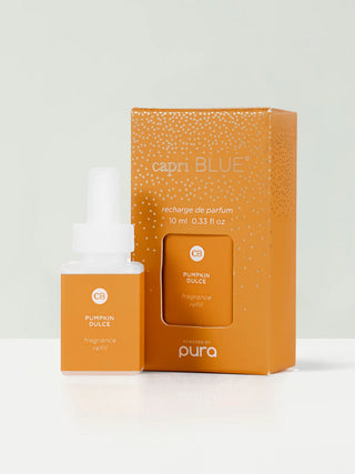 A Pura fragrance refill bottle with Capri Blue packaging, displaying the 'Pumpkin Spice' scent. The product is presented in a small clear bottle with a label, next to its orange box with dots design.