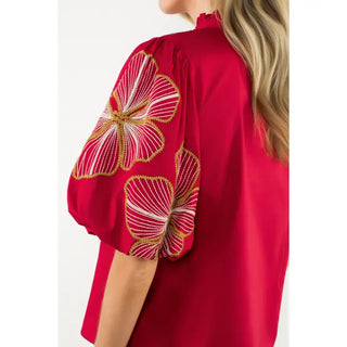 THML burgundy blouse with floral embroidery on sleeves against a white background