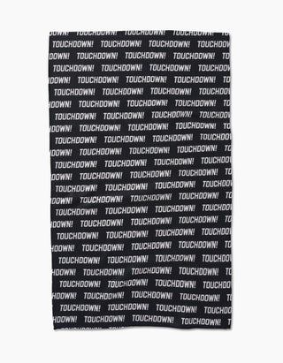 Black towel with 'TOUCHDOWN!' text pattern on a white background. Geometry Touchdown Tea Towel