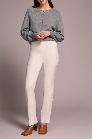 Person wearing a gray sweater and white pants on a plain background