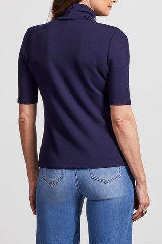A model wearing a navy blue mock neck, cotton tee with sleeves that go to the elbow.