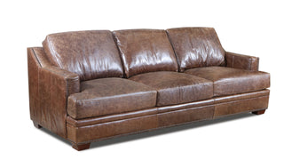A brown leather sofa with a track arm and nail head detailing.