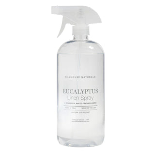 A clear spray bottle labeled Hillhouse Naturals Eucalyptus Linen Spray, with a white spray nozzle.