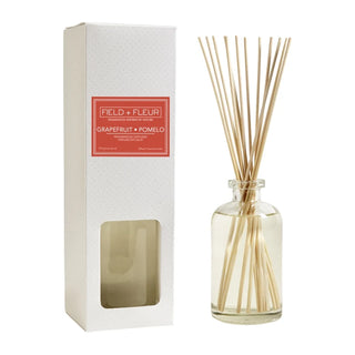 A clear glass diffuser bottle with light-colored reeds, packaged in a white box named 'Grapefruit Pomelo', Hillhouse Naturals