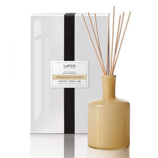 A LAFCO Chamomile Lavender 15 oz diffuser in a beige glass bottle with a black and white label, displayed next to its packaging box.