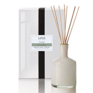 A LAFCO Feu de Bois 15 oz diffuser in a white vase with a black and white product box in the background.