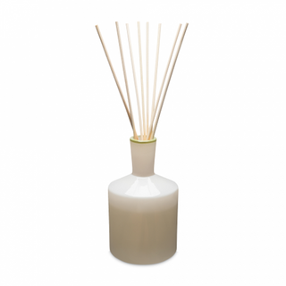 A beige LAFCO Feu de Bois diffuser with wood reeds, emitting a warm fragrance.