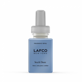 A small blue bottle with a white dropper labeled 'LAFCO NEW YORK Sea & Dune' refilling Pura smart fragrance diffuser.