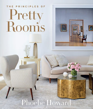 Book cover of 'The Principles of Pretty Rooms' by Phoebe Howard, featuring a photograph of a well-decorated living room with a white sofa, armchairs, and a coffee table, titled with the book's name. The Principles of Pretty Rooms Book.
