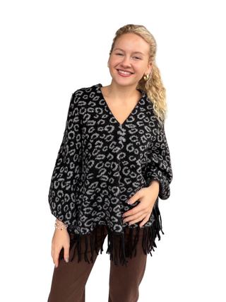 Woman in Animal Print Knitted Poncho in Black
