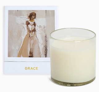 A hand-poured white candle in an artisan glass, with a card beside it featuring a painting of a angel. The candle is labeled 'GRACE', Anne Neilson Grace Candle