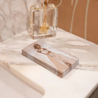 A stack of paper beige guest towels with a printed angel design, Grace Guest Towels, anne neilson