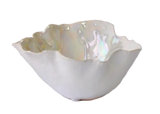 A white ceramic bowl with a fluted, scalloped edge and an iridescent pearlescent interior