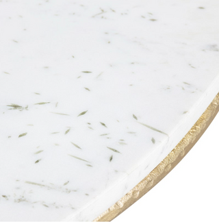 A contemporary style end table with a round white marble top and three gold metal legs.