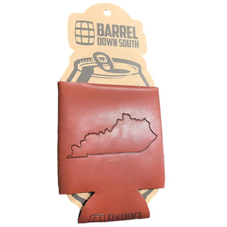 A brown faux leather can cooler with the Kentucky state outline embossed on it, mounted on a cardboard display with 'BARREL DOWN SOUTH' branding.