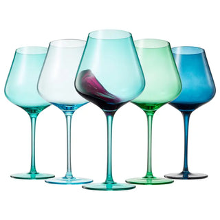 A set of five wine glasses in varying shades of blue and green, each with a large stem and a wide bowl, displayed against a white background.
