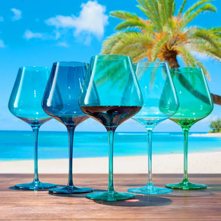 A set of five wine glasses in varying shades of blue and green, each with a large stem and a wide bowl.