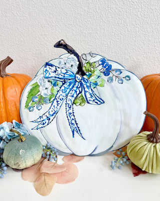 Beck's Autumn Hydrangea White with Blue Pumpkin Stake
A decorative white pumpkin sign on a metal stake, featuring a blue patterned bow, green leaves, blue berries, and a brown stem easel