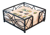 A black metal napkin holder with a geometric pattern, featuring a flat caddy style and ball feet.