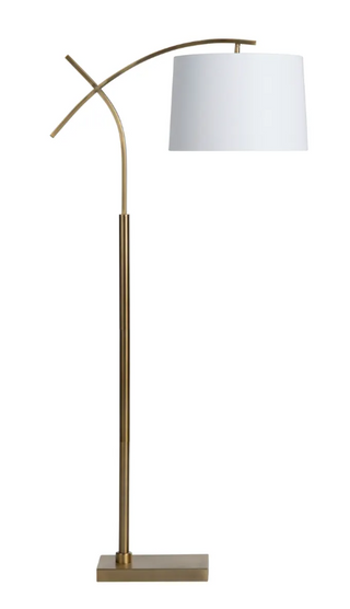 A modern floor lamp with a sturdy metal base in antique brass finish and a white linen tapered drum shade.