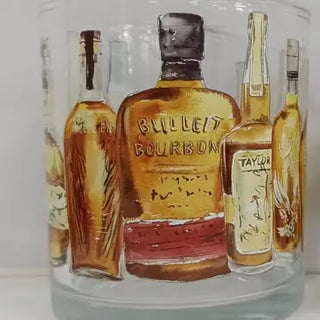 A clear rocks glass with painted bourbon bottle designs around the exterior. Bourbon Bottles Wrapped Rocks Glass