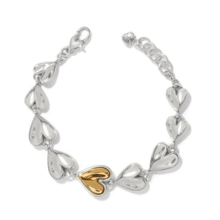 A bracelet featuring cascading heart-shaped links with the largest heart accent having a gold polished finish, with an adjustable lobster claw closure.Brighton