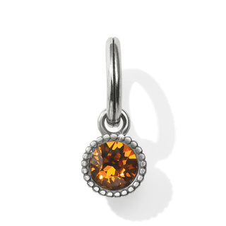 A faceted amulet with a orange-colored topaz crystal surrounded by smaller clear crystals, attached to a silver-colored metal ring. Brighton