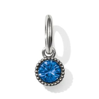 A faceted crystal amulet with a blue centerpiece surrounded by a silver-colored metal setting, designed as a pendant. Brighton