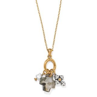 A gold-toned necklace with a lobster claw pendant featuring a silver cross and multiple charms, including a crystal and a potato pearl. Brighton