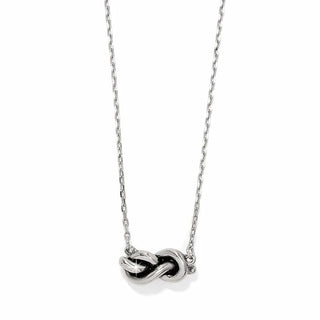 A silver-colored petite interlok knot necklace with an adjustable chain. Brighton