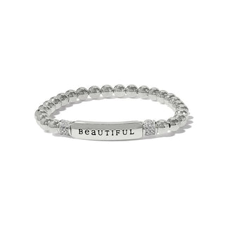 A silver-plated bracelet with the word 'beautiful' written on it, featuring a series of round charms linked together. Brighton