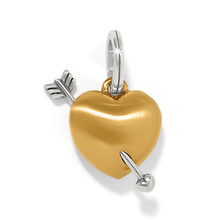 A golden charm shaped like a heart with a silver arrow piercing it, designed for use as a jewelry . Brighton