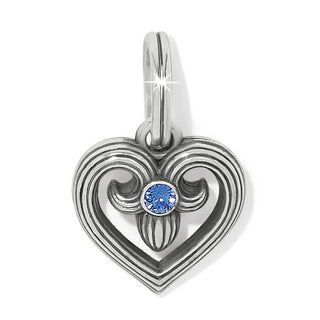 A silver-plated, heart-shaped charm with a blue fine crystal adornment.