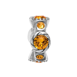 A silver-colored bead with a central orange topaz-hued crystal, designed in a halo shape with additional smaller beads surrounding it. Brighton
