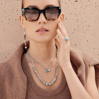 Woman wearing sunglasses, necklace, and ring against a beige background. Brighton Contempo Dot Dual Sunglasses