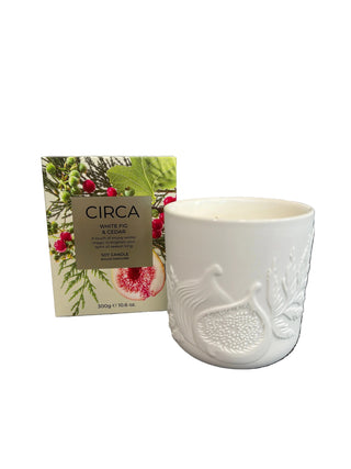 A white ceramic candle jar with embossed floral details. 